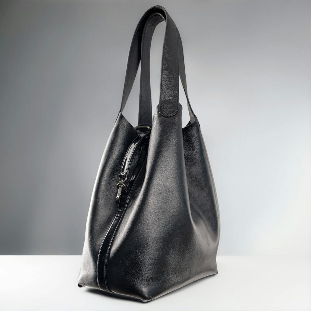 A chic studio shot of a luxury black leather handbag against a white background.