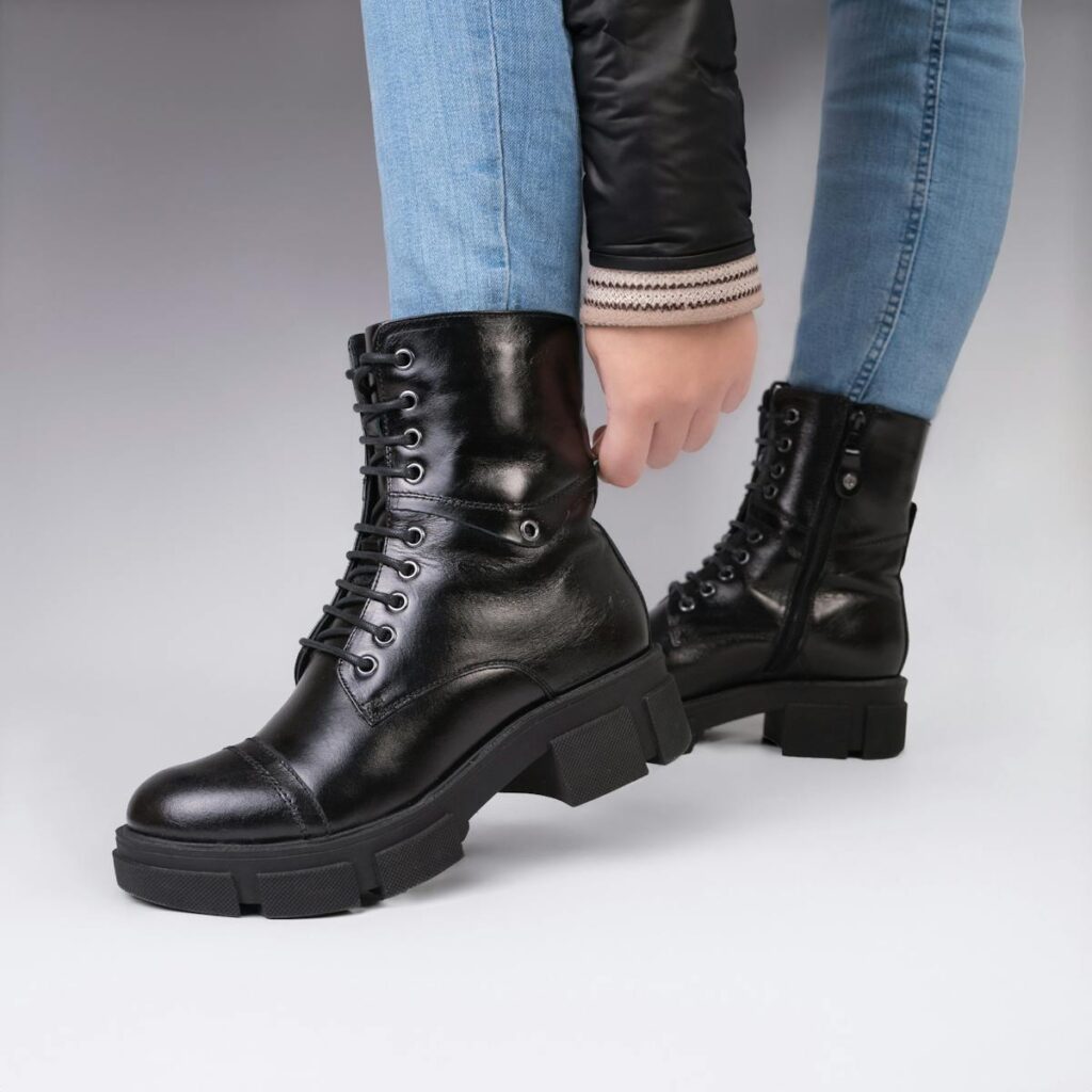 Close-up of a woman wearing stylish black leather boots, showcasing fashion and elegance.