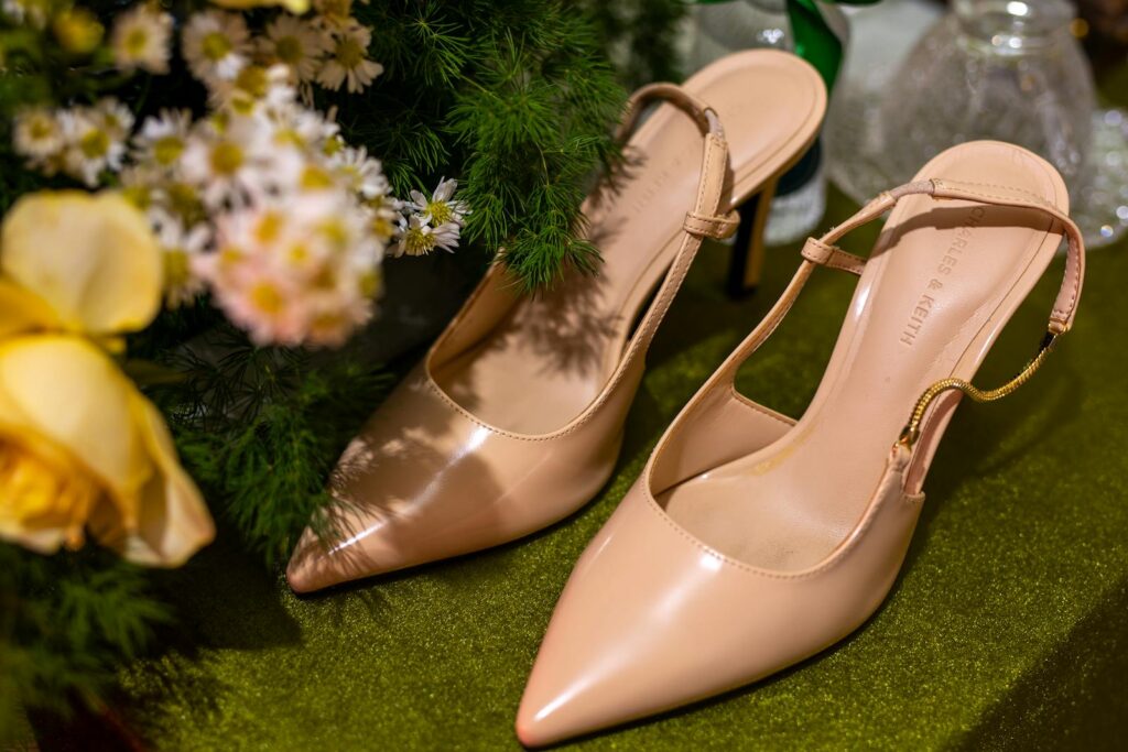 Chic nude high heels surrounded by vibrant flowers in Bien Hoa, Vietnam.