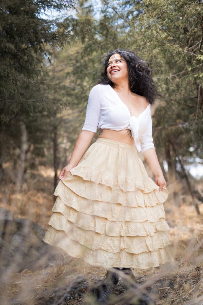 Joyful woman in ruffled skirt enjoying a sunny day outdoors.