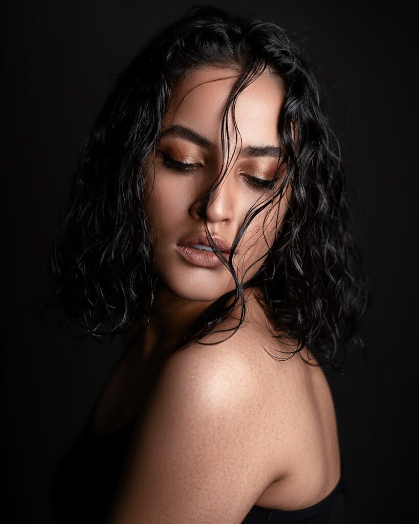 Striking portrait of a woman with short wet hair in a studio setting, exuding elegance and confidence.