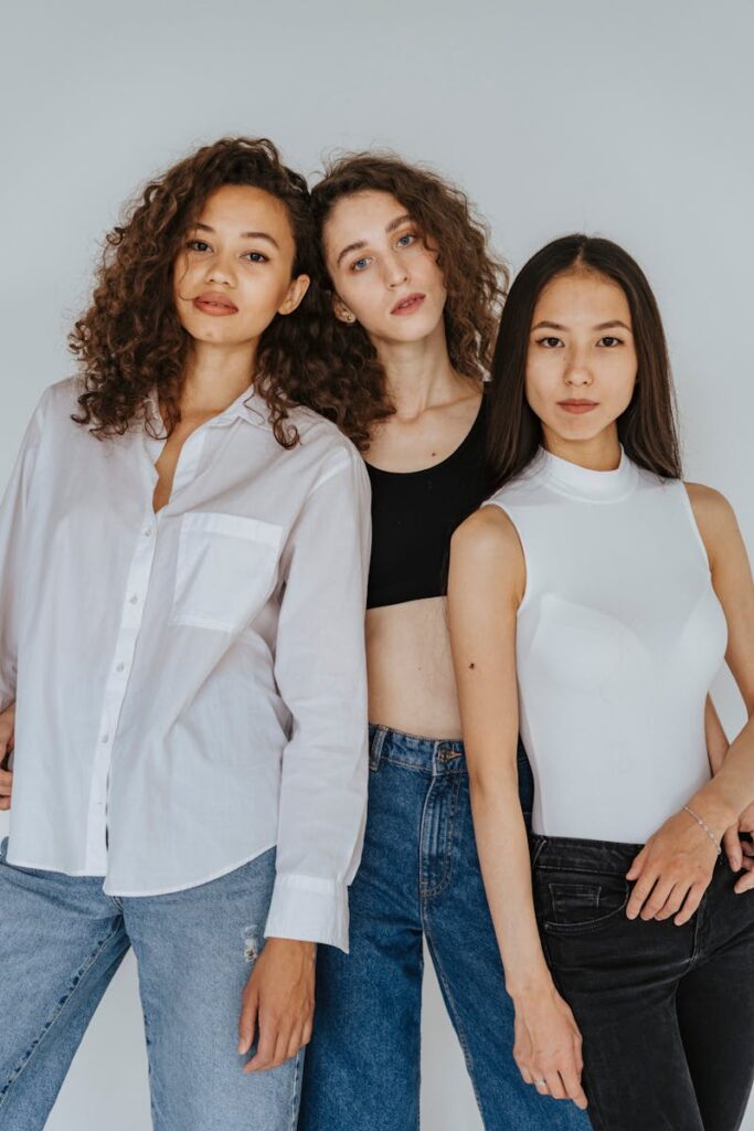 Three stylish women in a studio setting highlighting contemporary fashion and diversity.