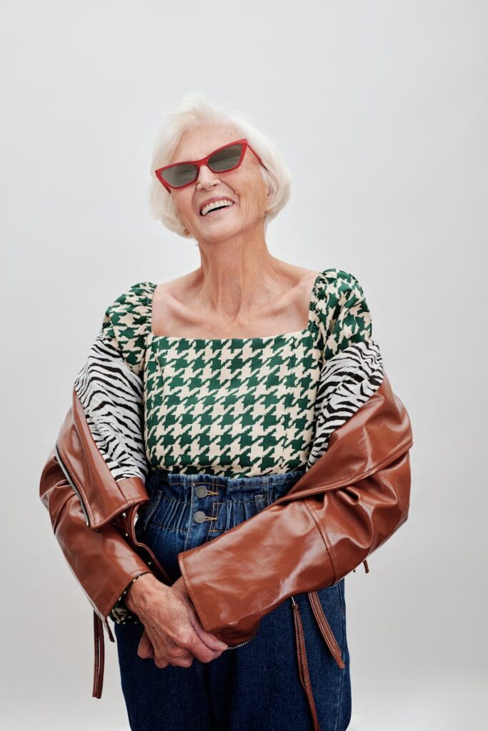 A fashionable senior woman wearing chic sunglasses and a trendy outfit, exuding confidence.