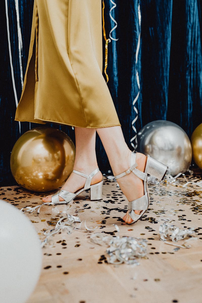 Silver sandals amidst gold and silver balloons, capturing a chic party atmosphere.
