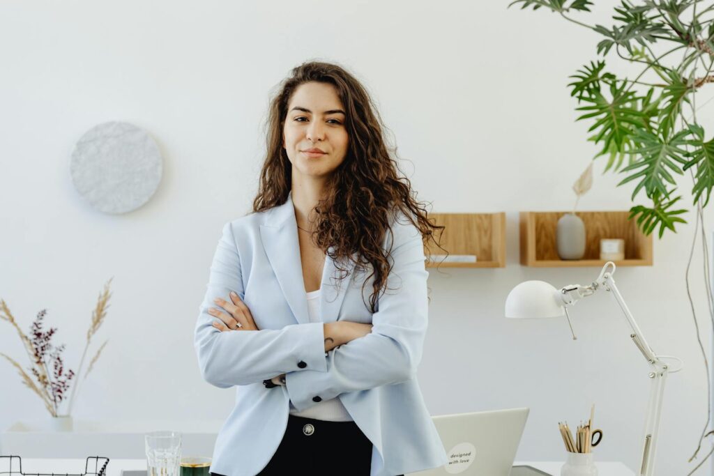 Professional woman with curly hair exuding leadership in a contemporary office environment.