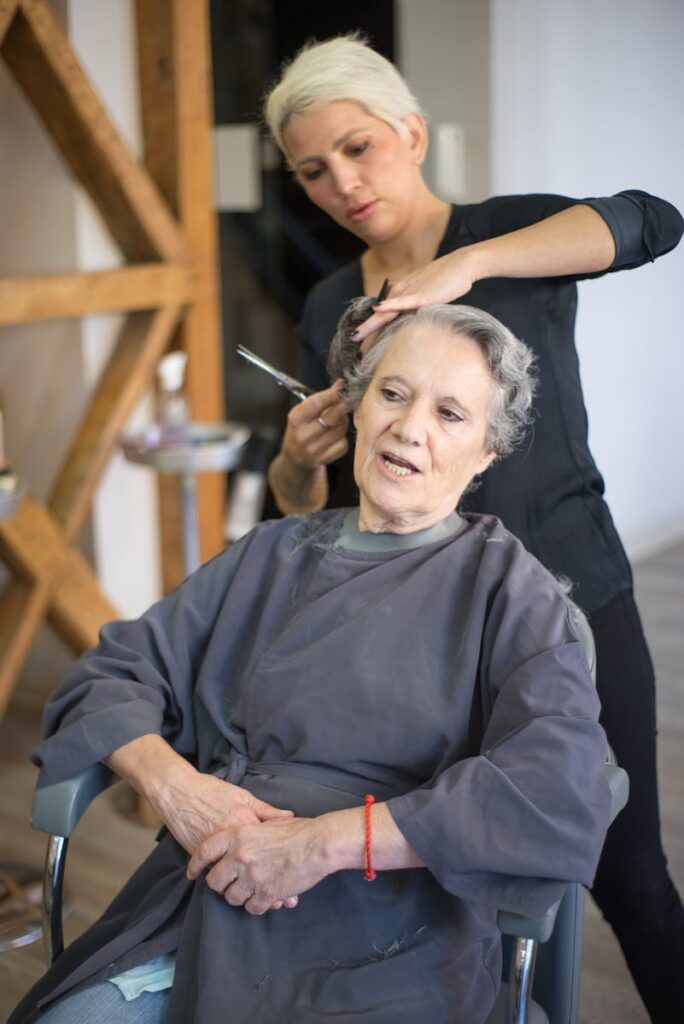 Elderly woman having hair styled by a stylist in a Portuguese salon.