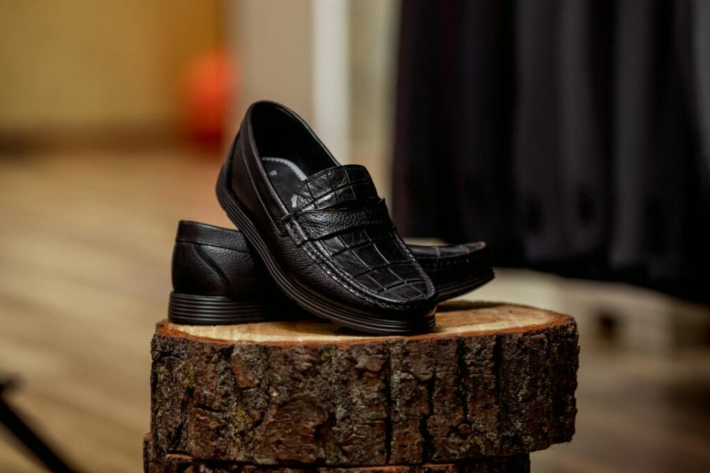 Stylish black loafers displayed on wood, highlighting detailed craftsmanship.