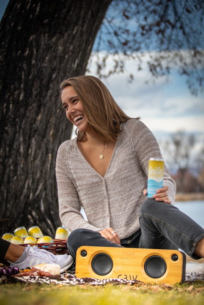 woman in gray cardigan sitting on brown wooden bench