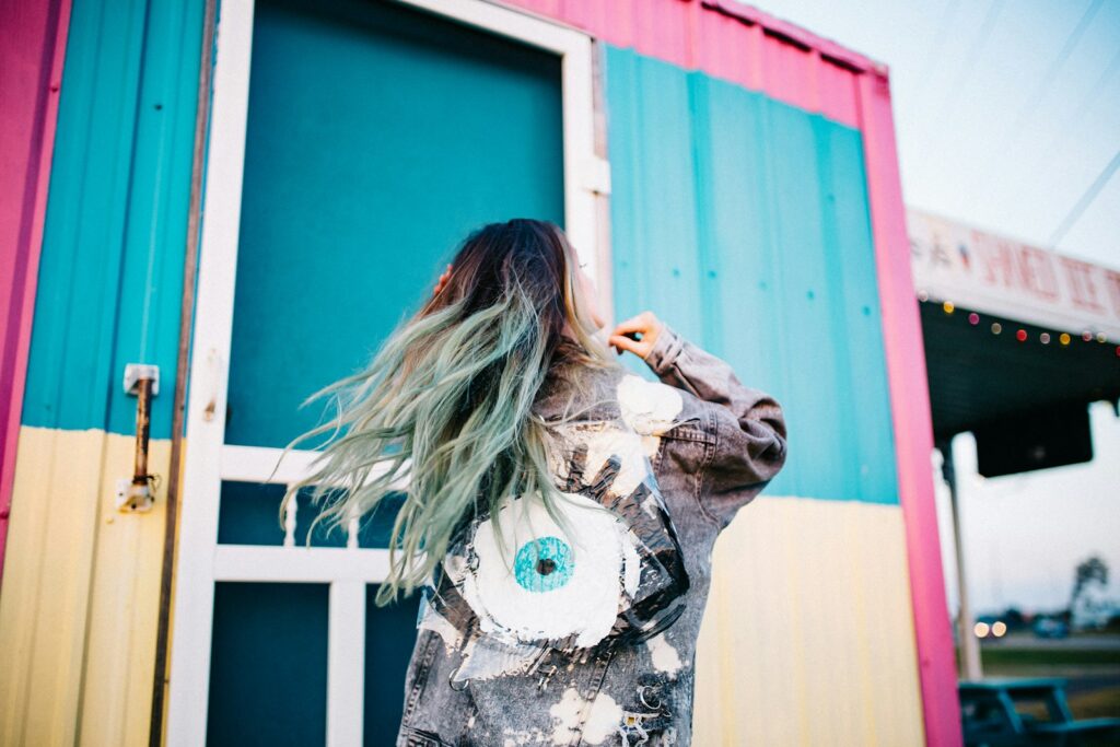 woman wearing grey denim jacket standing beside intermodal container