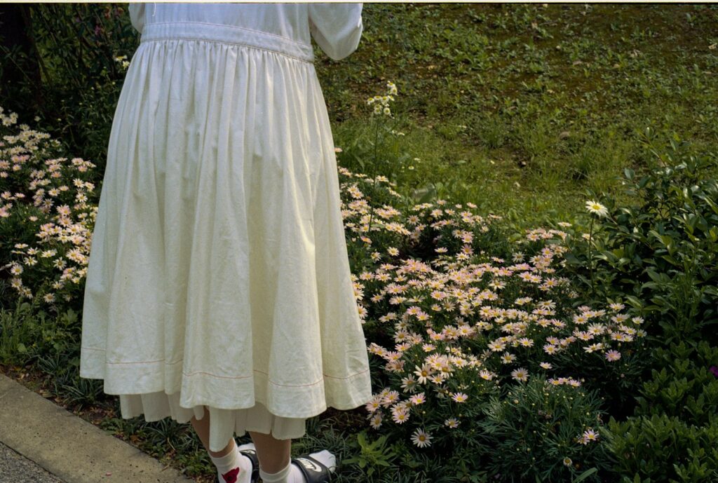 woman in white dress standing on green grass field