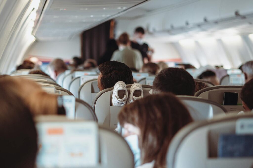 View of passengers wearing masks and seated in economy class during flight.