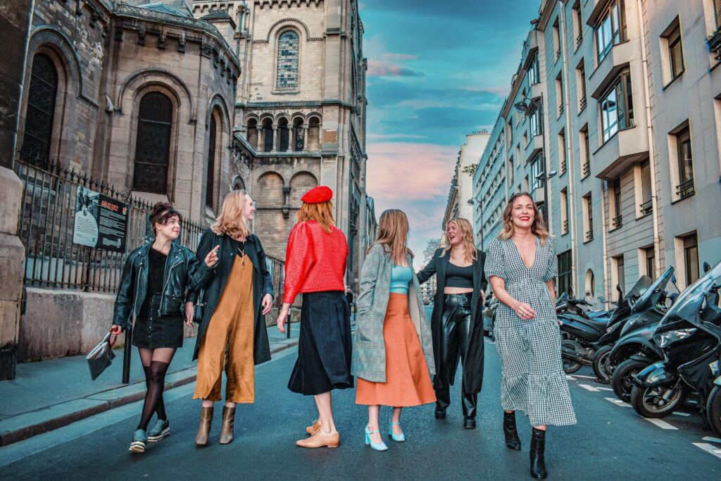 A group of fashionable women walking down a picturesque Paris street, showcasing modern style.
