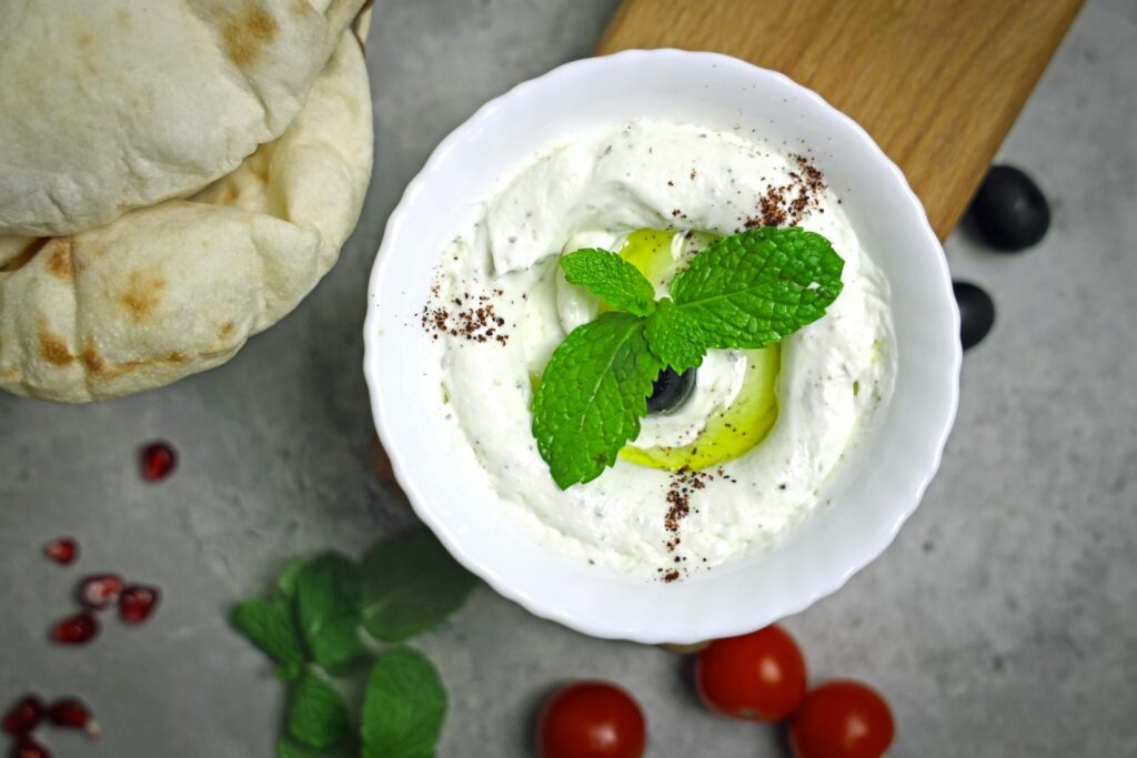Creamy Greek yogurt dip garnished with mint and olive, perfect for a healthy snack.