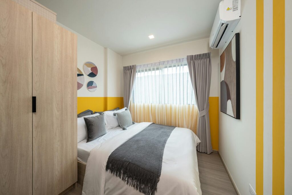 Elegant bedroom interior with modern decor, yellow accents, and natural light.