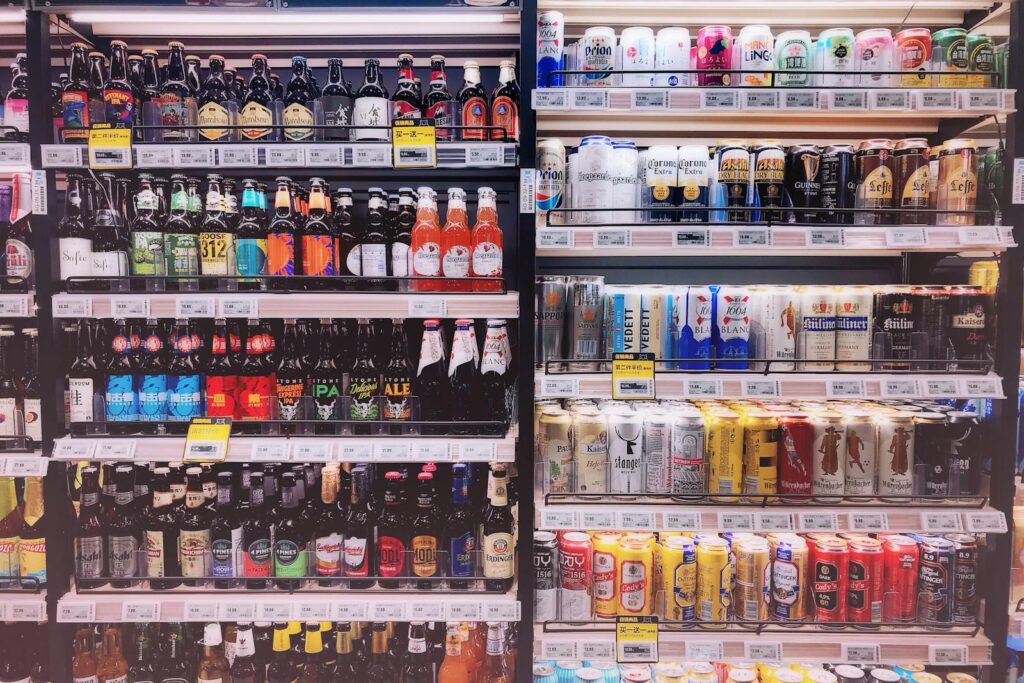 Wide variety of bottled and canned beers displayed on store shelves in Shanghai, China.