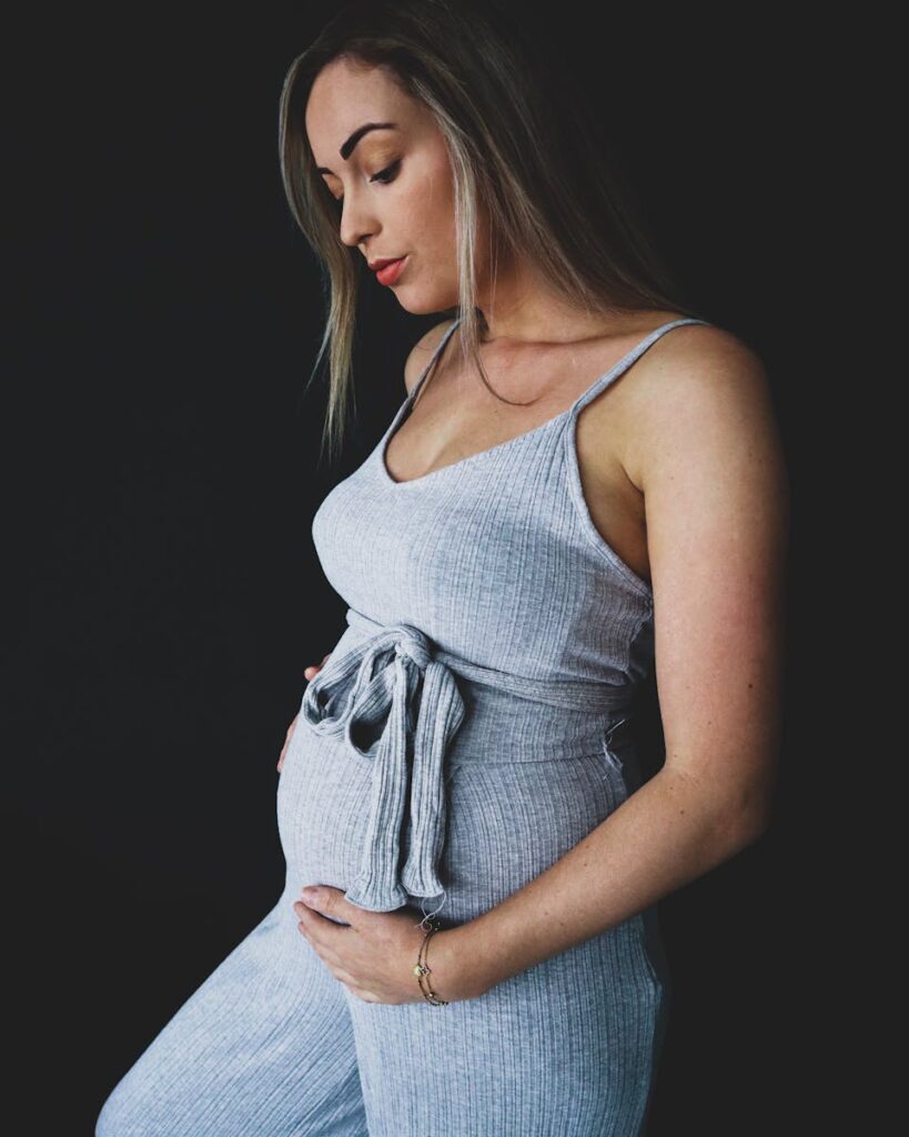 Stylish portrait of a pregnant woman embracing her baby bump.