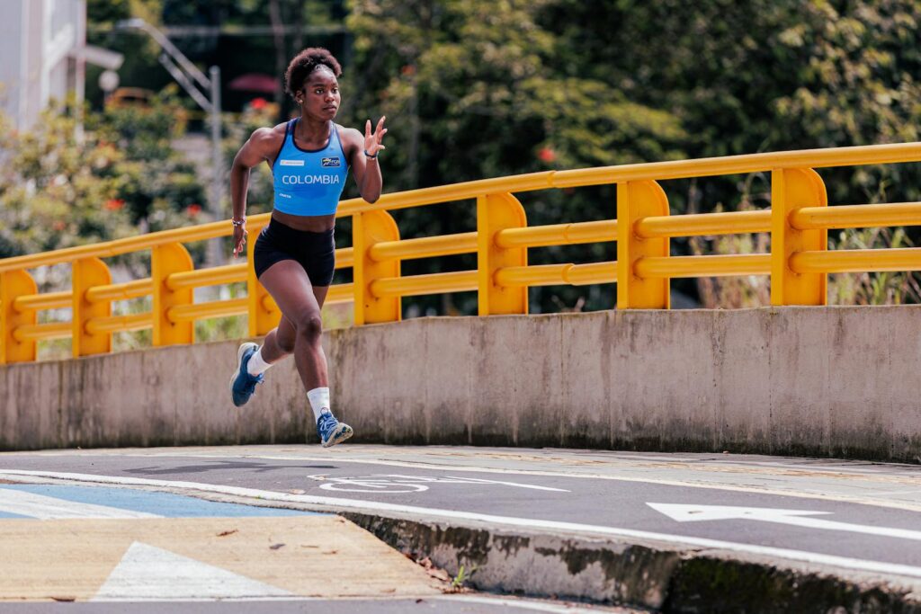 Athletic woman running on an outdoor city road, wearing Colombia sports gear.