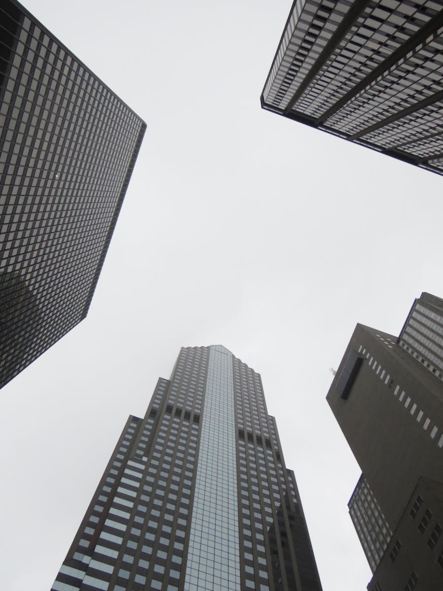 Upward view of skyscrapers with cloudy sky, showcasing modern architecture.