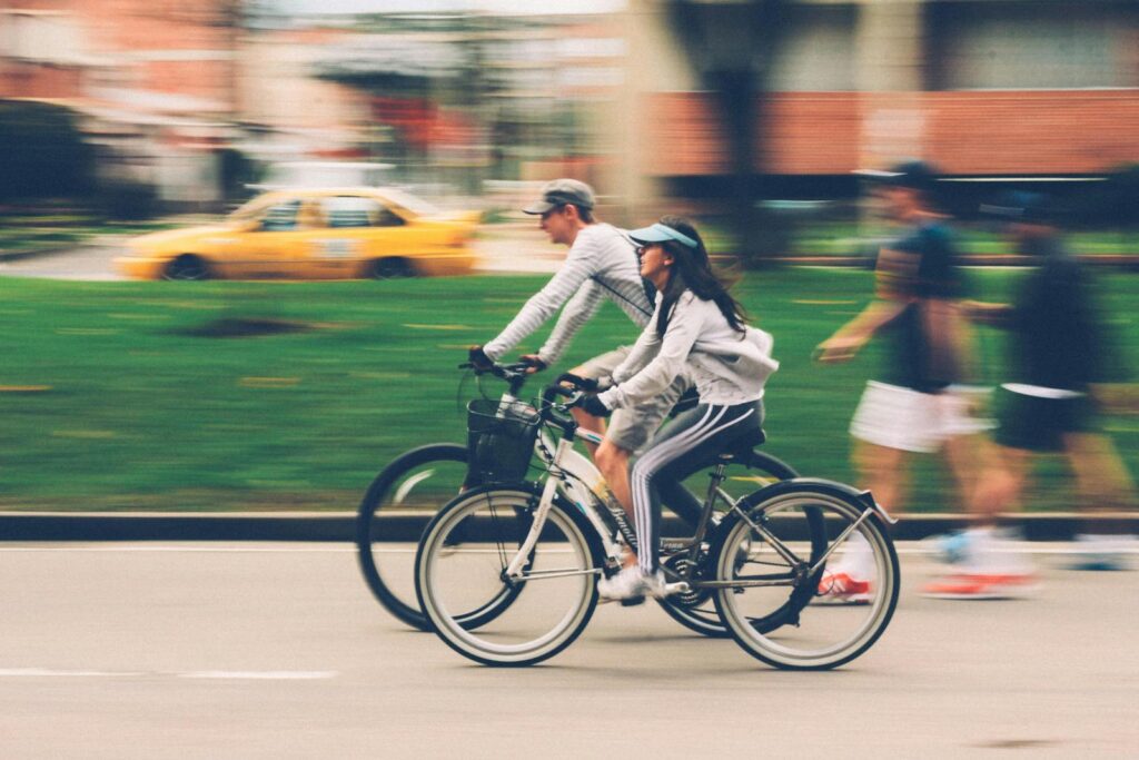 Blurred image of a couple cycling in a city street, capturing speed and motion.