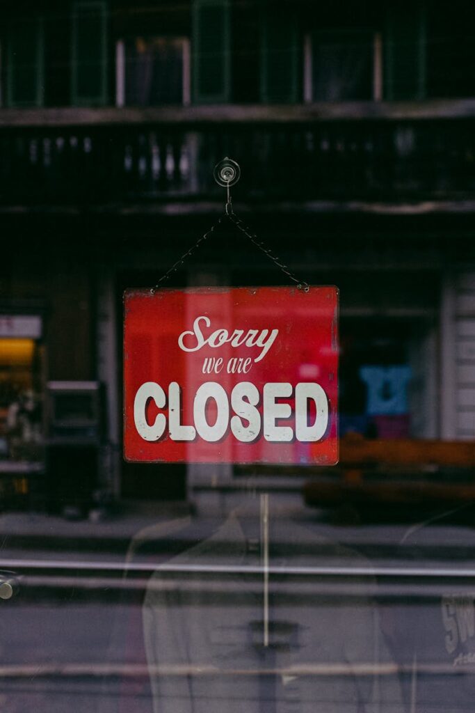Red 'Sorry We Are Closed' sign displayed in a shop window indicating closure.