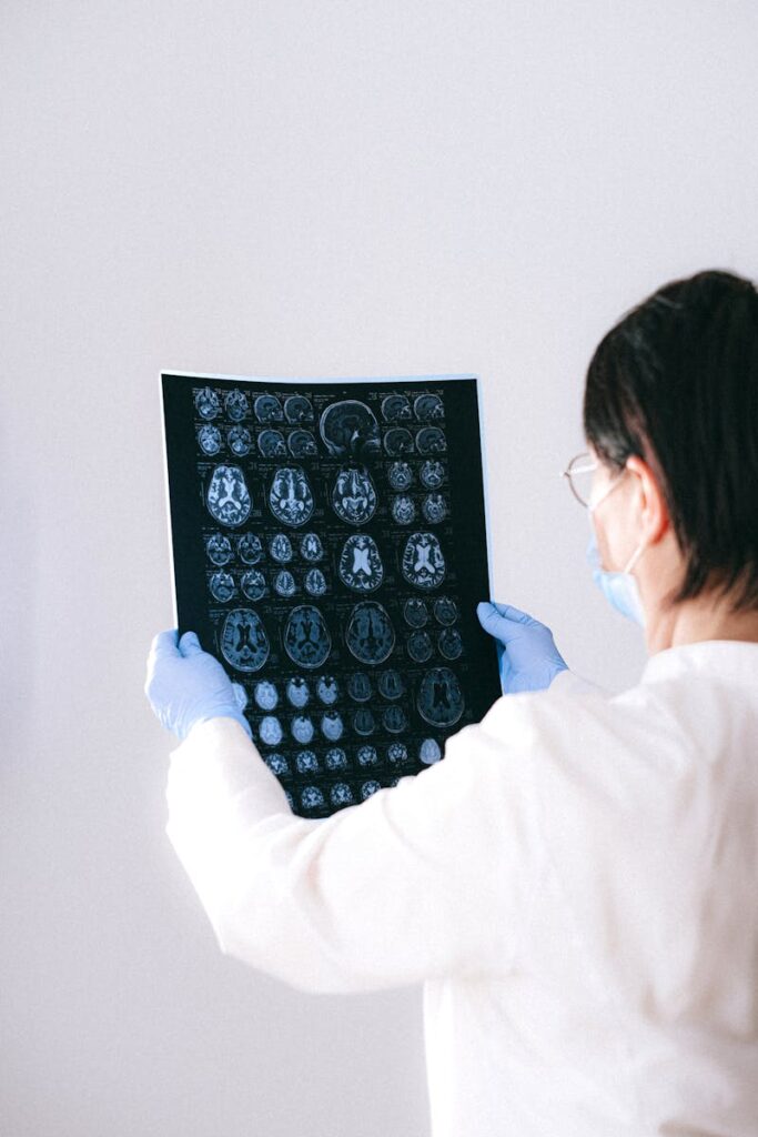 A radiologist holds and examines a detailed MRI scan, showcasing medical expertise in a clinical setting.