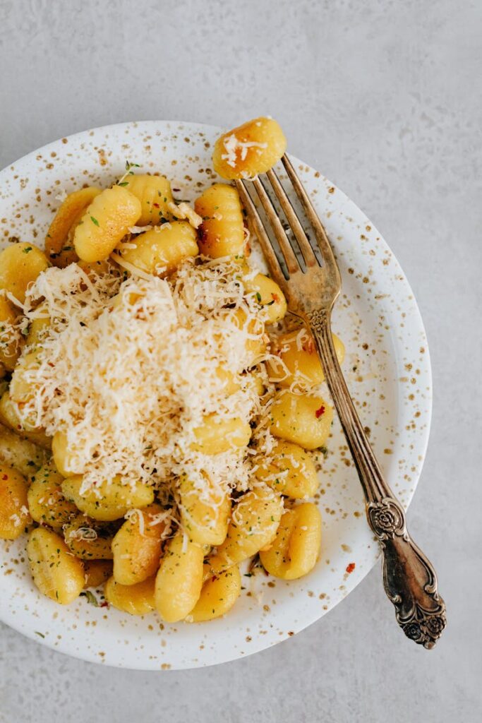 Delicious gnocchi topped with freshly grated parmesan, styled in a rustic setting.