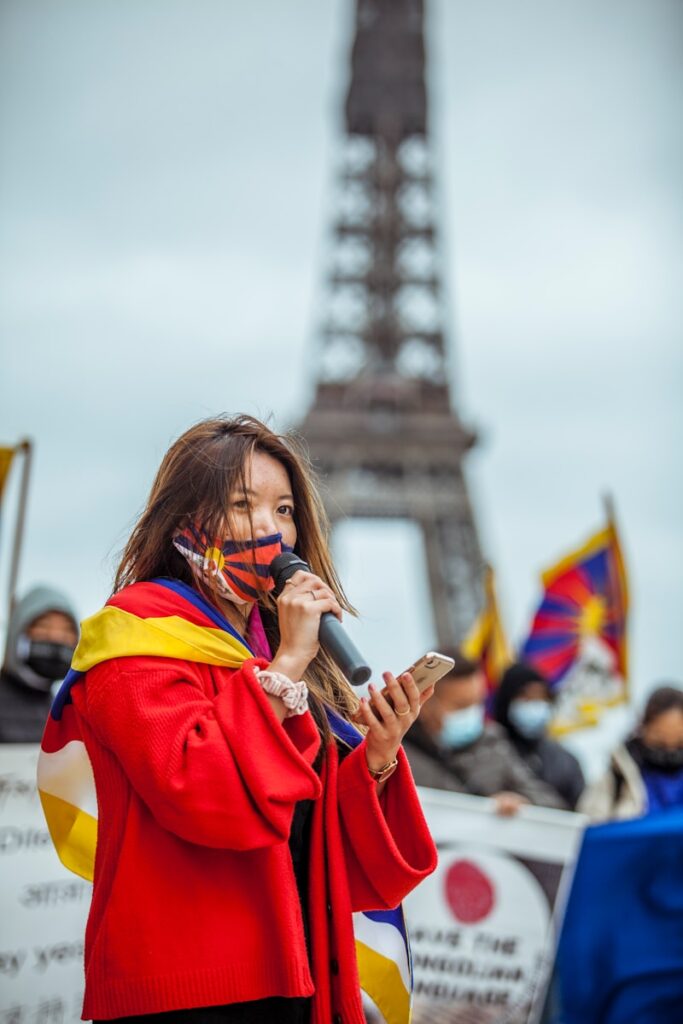 woman in red coat holding smartphone