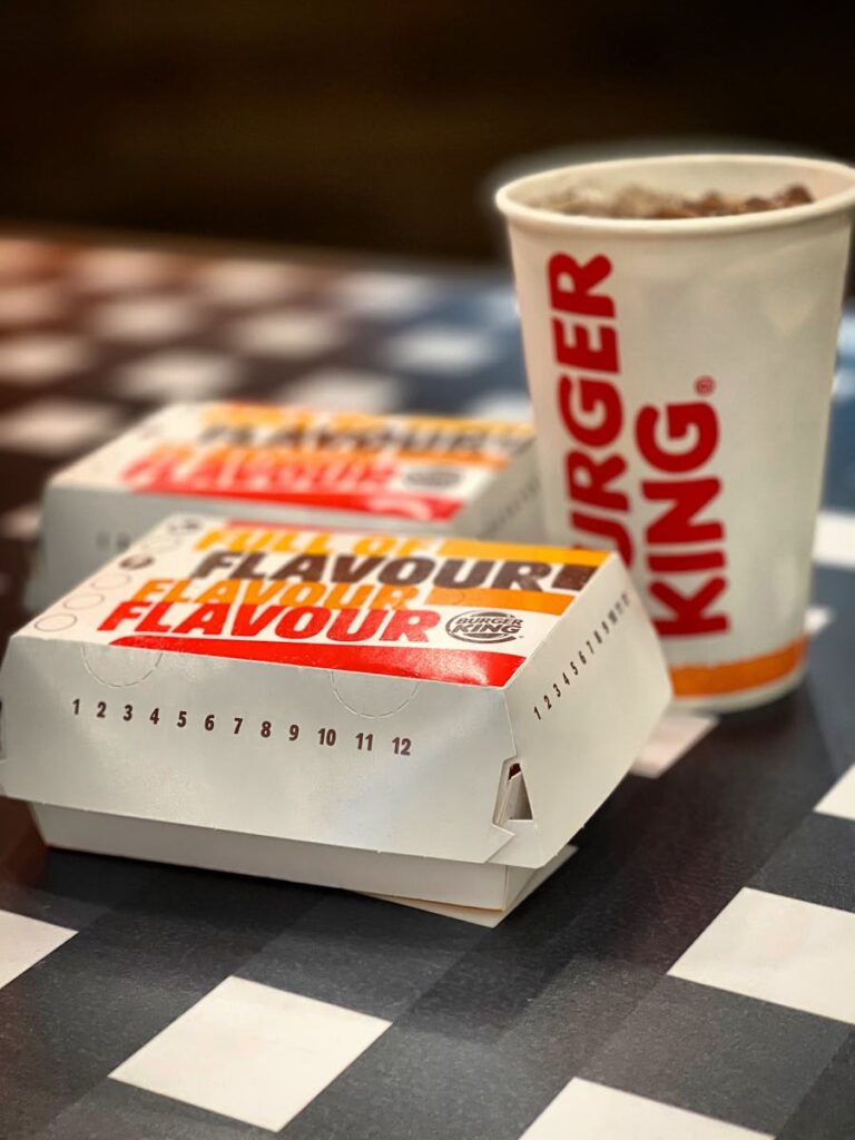 A fast-food meal with Burger King packaging on a stylish checkered table.