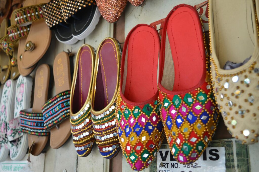 Vibrant display of traditional embroidered and beaded slippers hung on a wall.