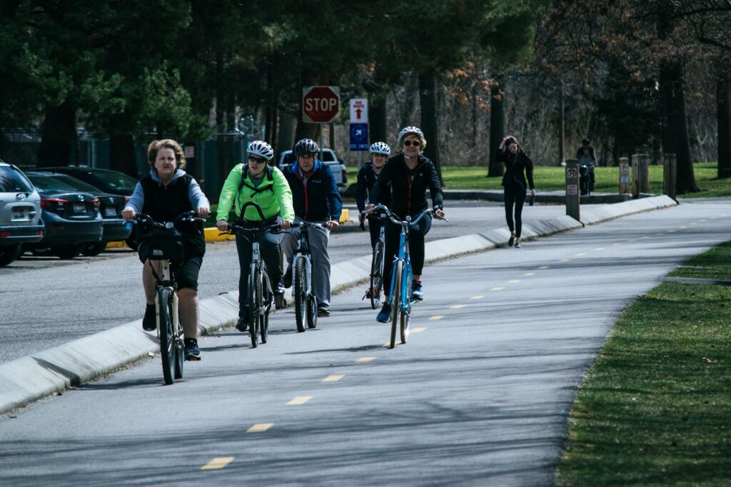 A diverse group of cyclists enjoying a ride on a sunny outdoor bike path.