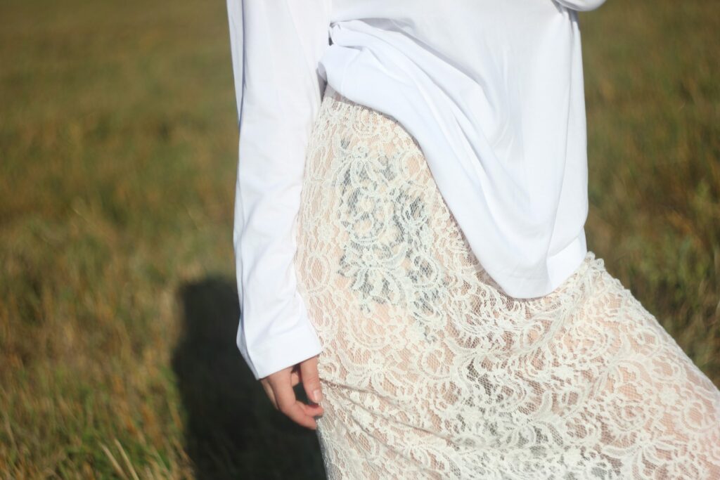 Woman in a white shirt and lace skirt.