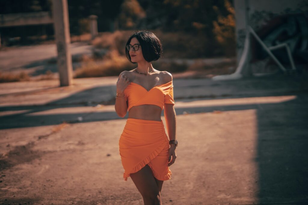 a woman in an orange dress posing for a picture