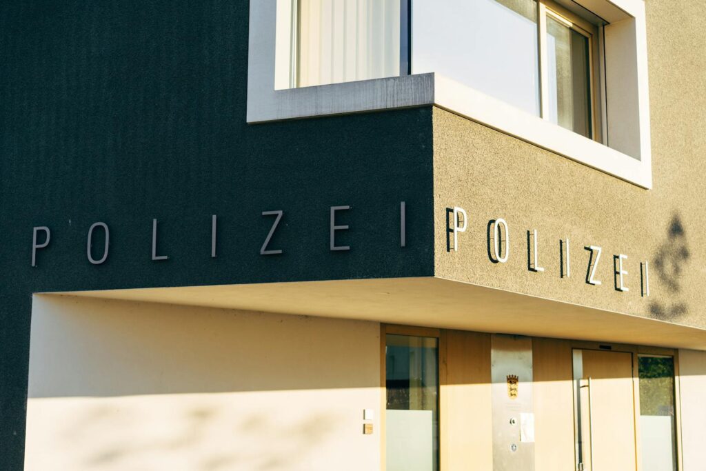 A close-up of a modern police station facade in Germany with clear signage.