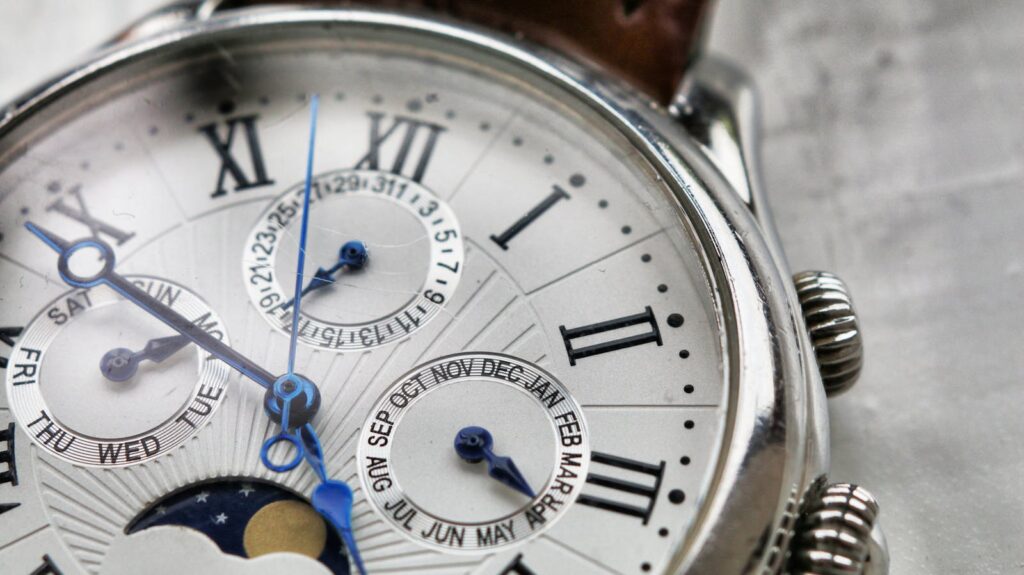 Detailed macro shot of an antique analog wristwatch with Roman numerals and calendar face.