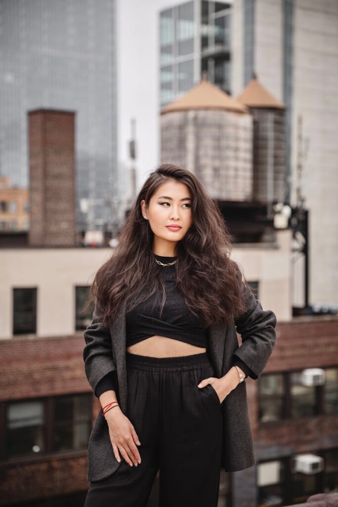 Portrait of a confident woman on a rooftop in New York with skyscrapers in the background, exuding style and empowerment.