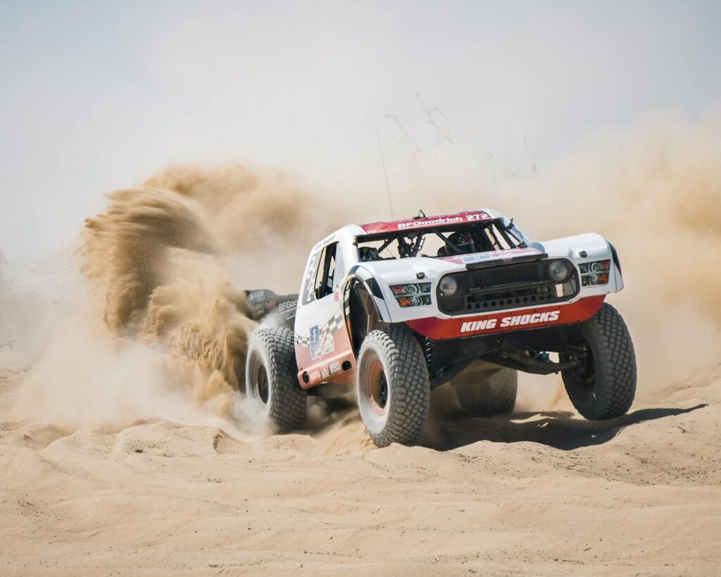 Dynamic shot of an offroad vehicle kicking up sand in a Mexico desert.
