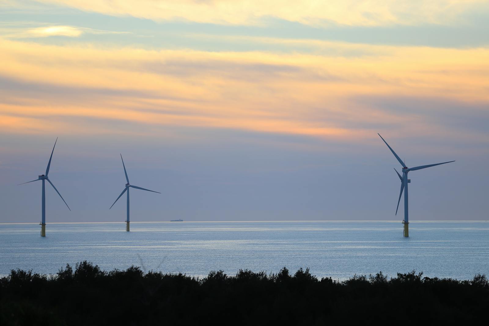 Beautiful view of offshore wind turbines at sunset in Taiwan, highlighting renewable energy.