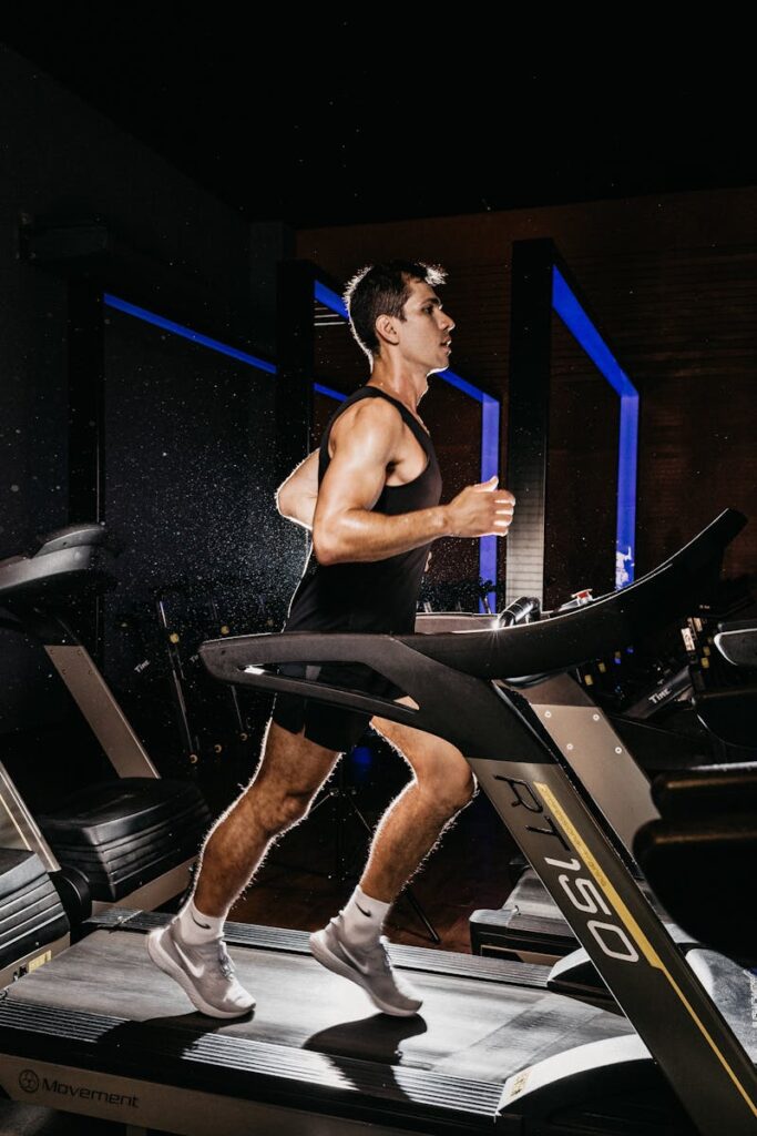 Man exercising on a treadmill indoors, showcasing fitness and determination.