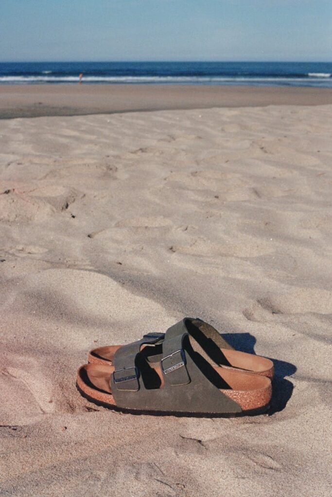 Pair of sandals on a sandy beach in Âncora, Viana do Castelo, Portugal.