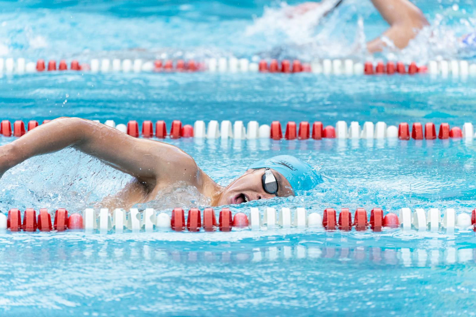 Swimmer in action during a competitive race at an outdoor swimming pool.