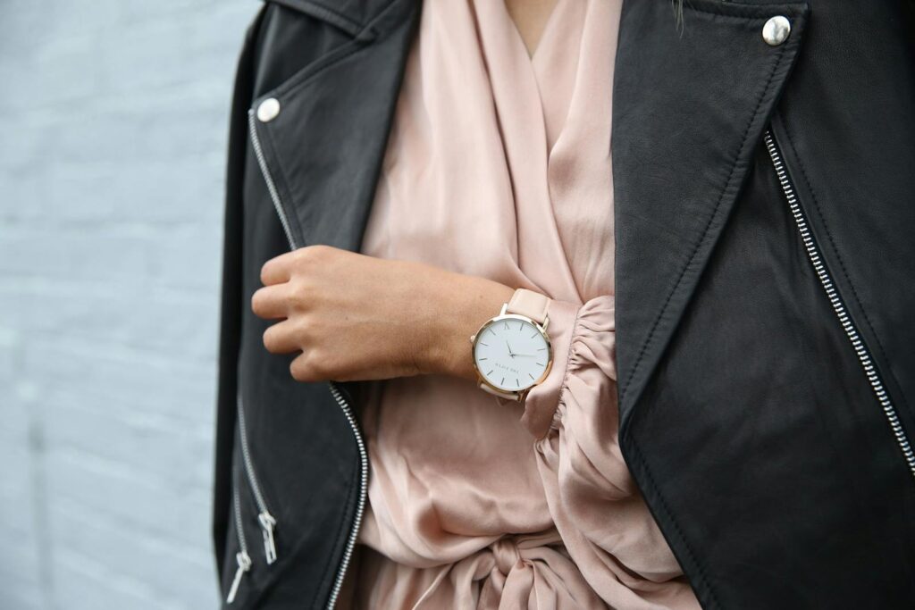 Stylish woman in a leather jacket showcasing an elegant wristwatch, perfect for fashion-forward individuals.