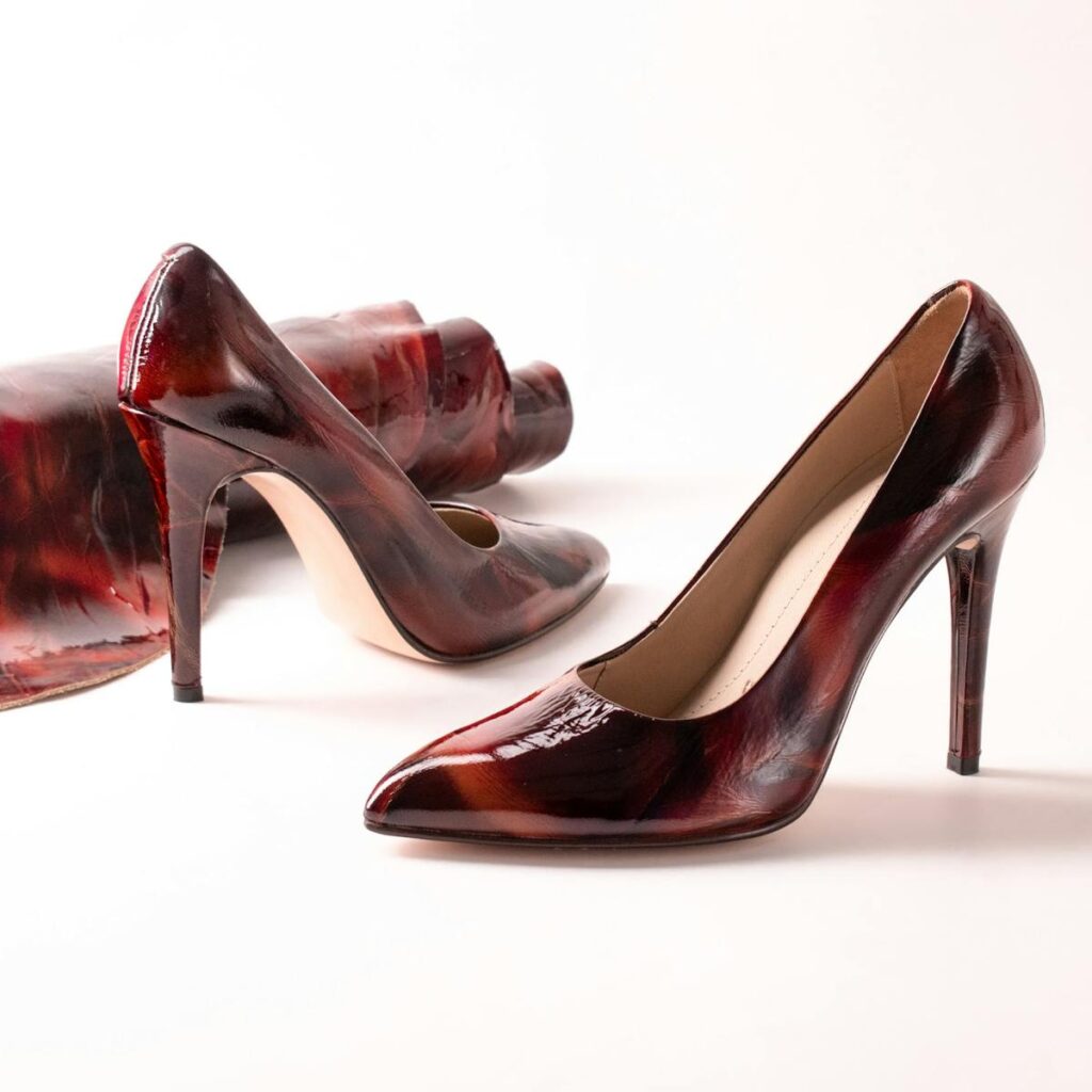 Elegant burgundy high heel shoes highlighted in a studio setting, emphasizing fashion and style.