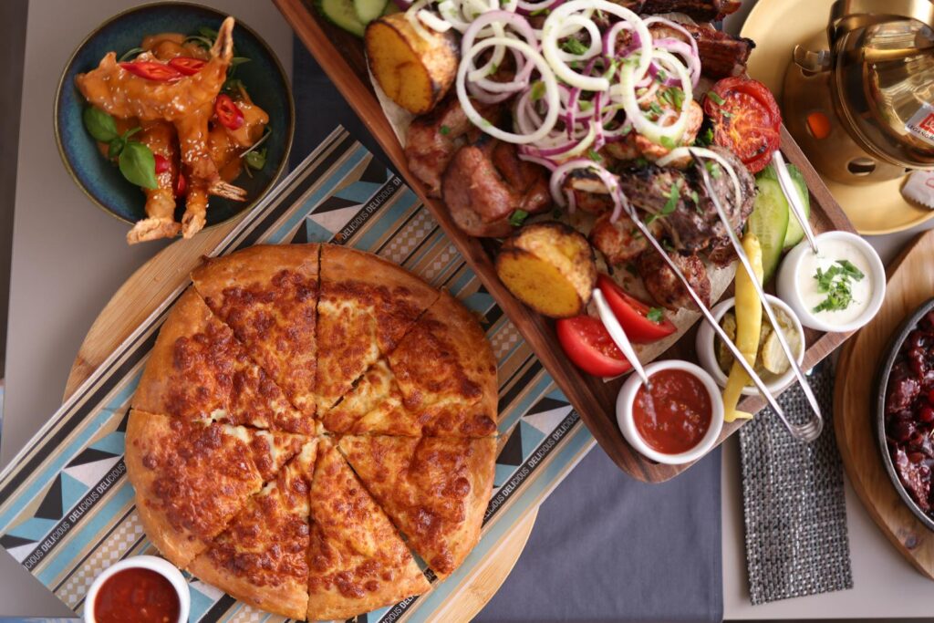 A vibrant top-down view of a delicious spread including pizza and assorted meats.