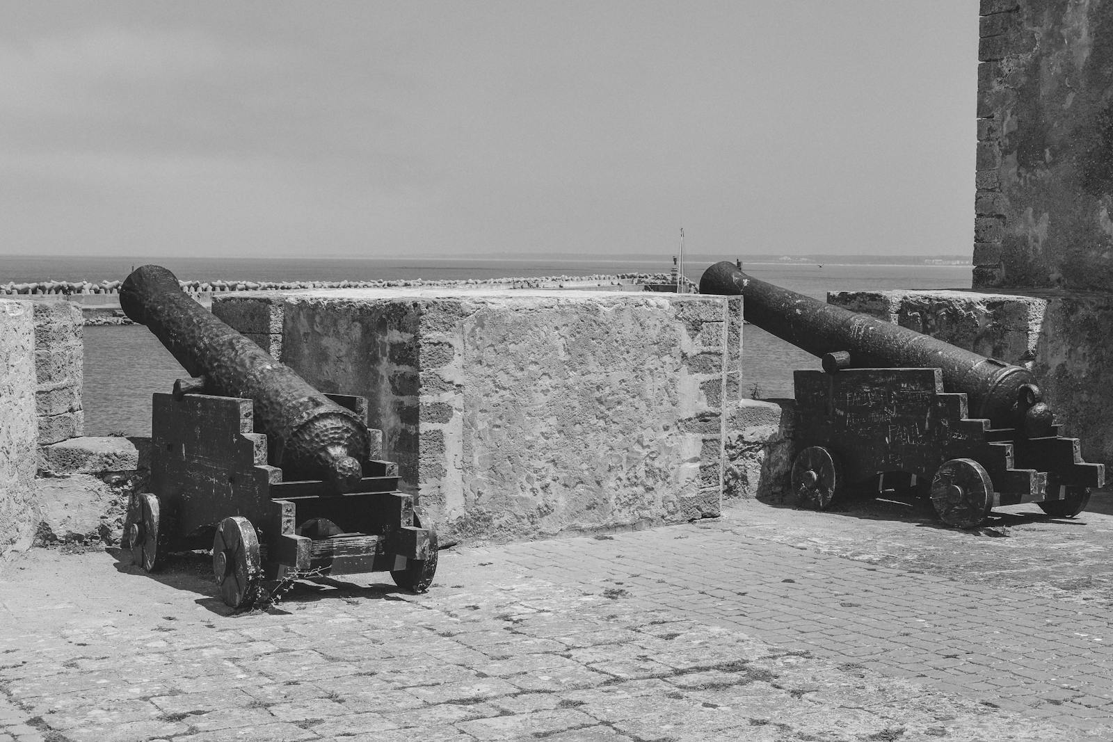 Black and white image of historic cannons facing the sea in El Jadida, Morocco.