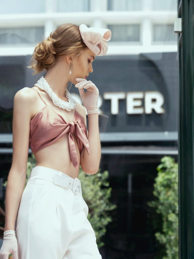 Chic woman in elegant summer fashion posing outdoors, embodying glamour and sophistication.