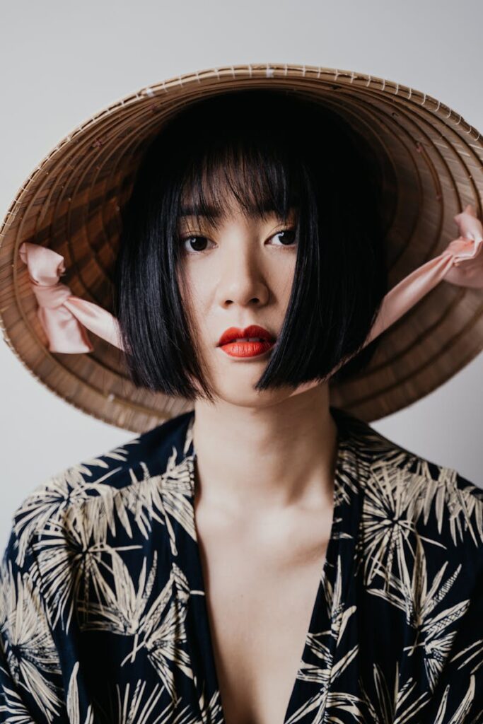 Close-up portrait of a woman with red lips and a traditional hat.