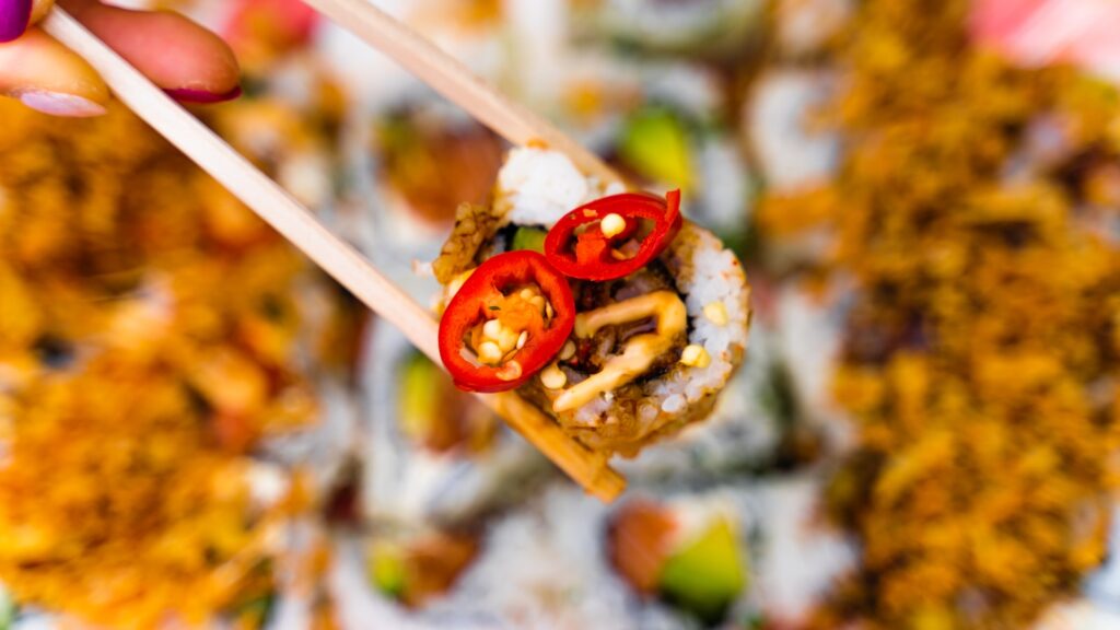 a person holding a chopstick with food on it