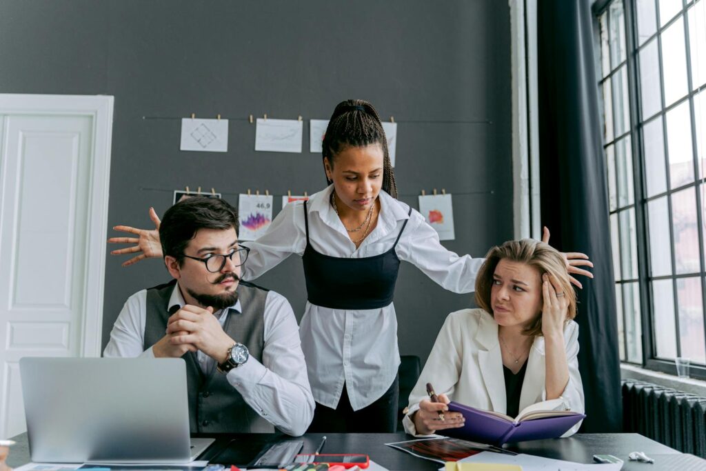 A diverse group of employees experiencing conflict at the office, depicting frustration and gesturing.