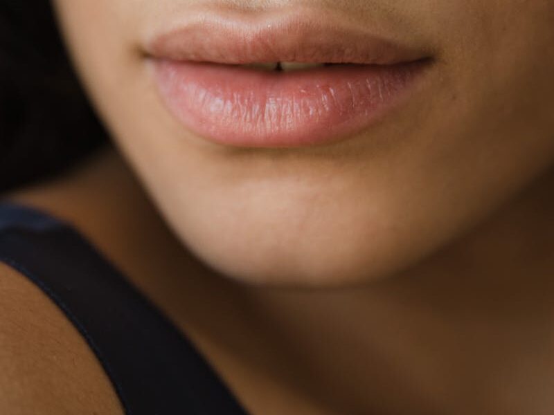Close-up image of a woman's lips showcasing smooth and healthy skin tone.
