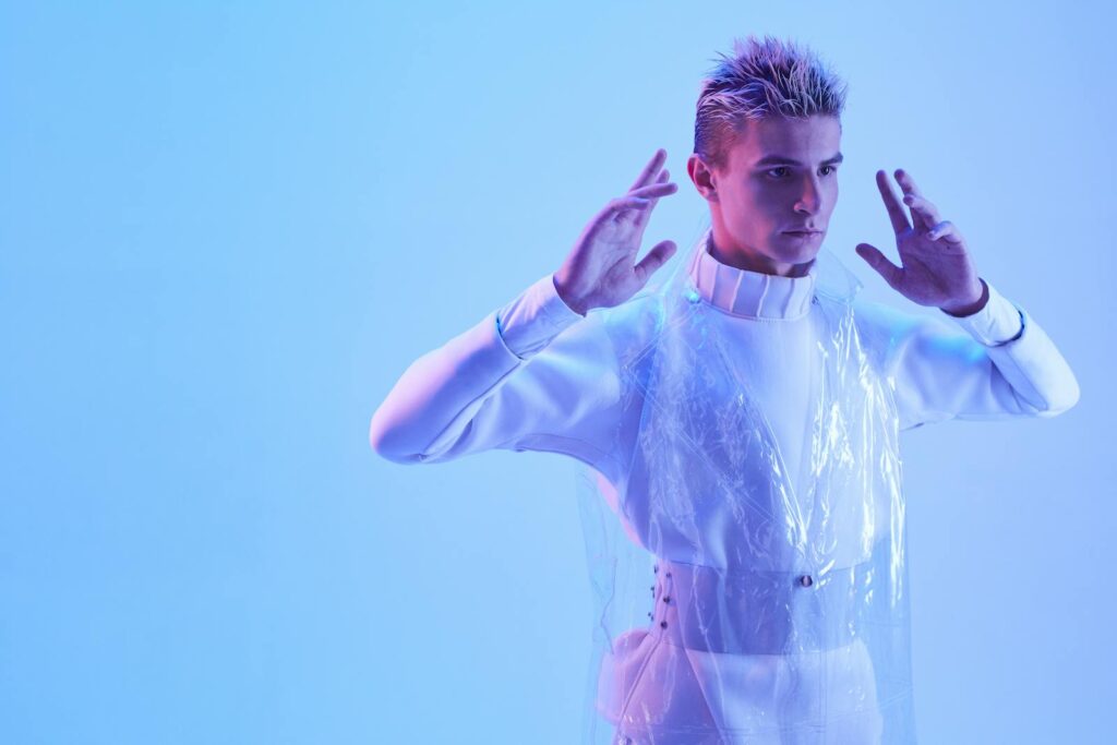 Futuristic portrait of a man in a studio with blue lighting, exuding cybernetic vibes.